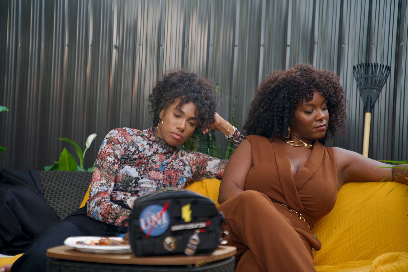 A still from GREEN — two women seated on an outdoor set